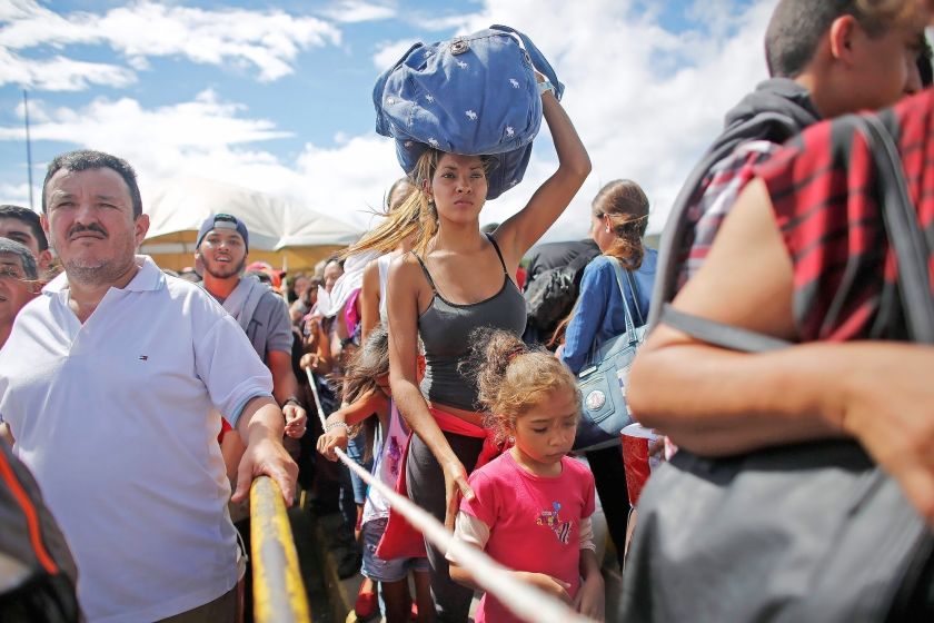 Venezolanen wachten aan de grens met Colombia tot ze het buurland binnen mogen om daar levensmiddelen en andere artikelen te kopen die in Venezuela zelf niet meer te krijgen zijn. (ap / Ariana Cubillos)