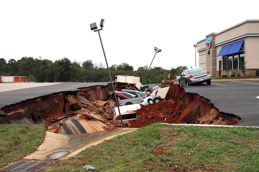 Auto’s liggen over elkaar heen gebuiteld nadat een parkeerdek in de plaats Meridian, Mississippi (VS) zaterdag instortte. Deskundigen zoeken nog naar de oorzaak achter de breuk die een groot gat in het wegdek sloeg. (ap / Michael Stewart)