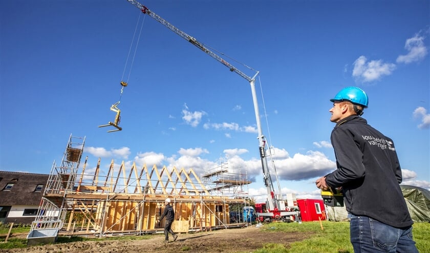 Ecologisch aannemer Jan-Willem van Engen bedient een elektrische kraan op een bouwplaats in Wageningen waar bijna stikstofvrij wordt gebouwd. (Raymond Rutting)
