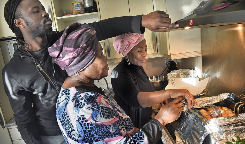 Afribollen in de maak bij de Rotterdamse familie Gwanmesia. Achteraan Barbara, vooraan haar moeder, links haar zoon Beng. (Marcel van den Bergh)