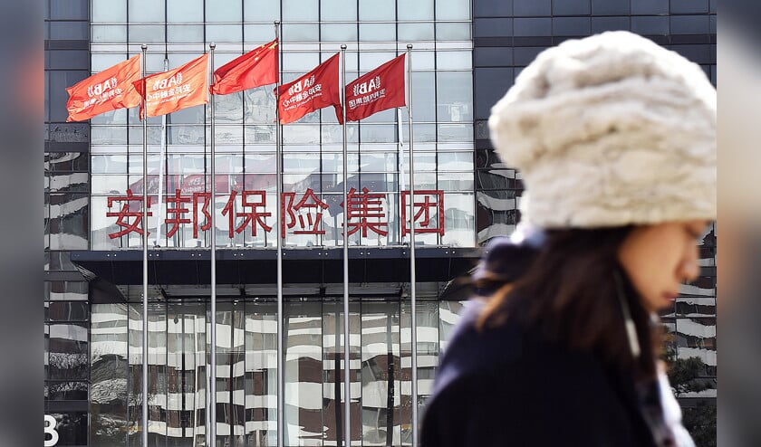 Een vrouw loopt in Peking langs een gebouw van Anbang Insurance Group, die voor minimaal een jaar lang onder Chinese overheidscontrole staat. (kyodo)