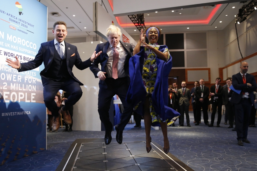 De Britse premier Boris Johnson springt met twee CEO's in de lucht op een innovatiebeurs in Londen. Ze testten een vloer die voetstappen omzet in energie. (beeld epa / Hollie Adams)