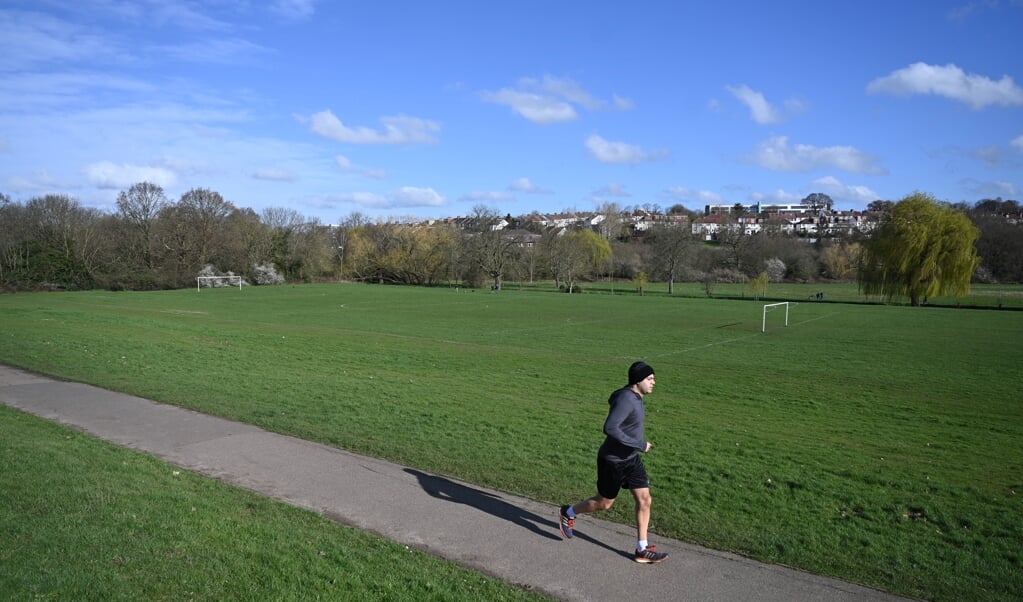 2020-03-21 10:12:37 epa08311151 An elderly man jogs at the Oak Hill Park in north London, Britain, 21 March 2020. Britain's Prime Minister Boris Johnson has urged UK citizens to avoid unnecessary social contacts, to work from home where possible, and to close schools, pubs and restaurants. Several European countries have closed borders, schools as well as public facilities, and have cancelled most major sports and entertainment events in order to prevent the spread of the SARS-CoV-2 coronavirus causing the Covid-19 disease. EPA/NEIL HALL (beeld EPA)